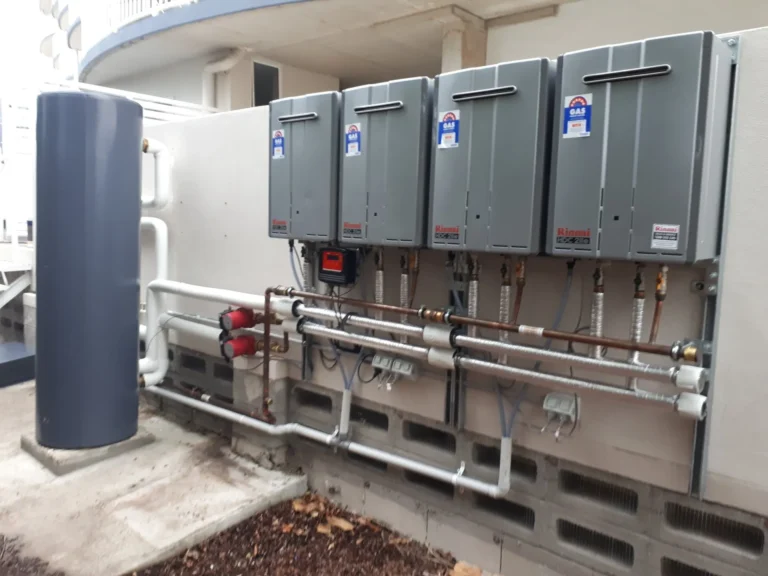 A bank of continuous flow gas hot water units mounted outside a commercial building