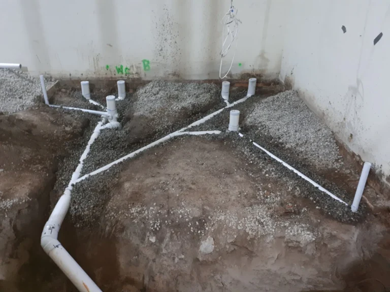New PVC drainage pipework laid in an excavated floor