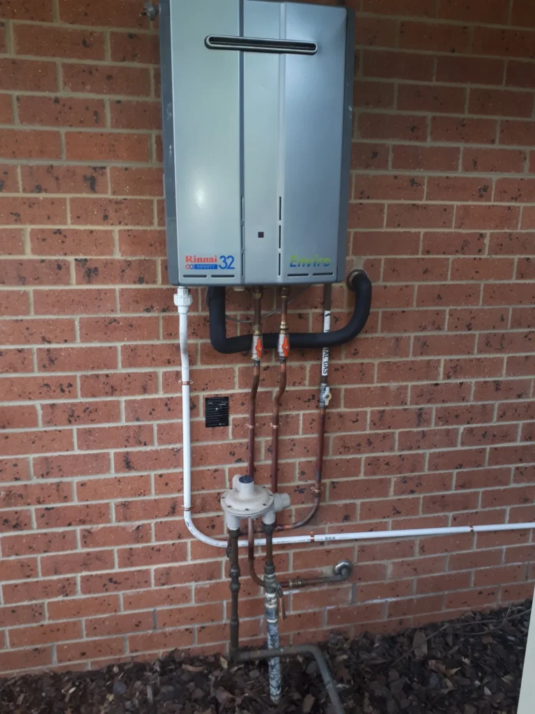 Continuous-flow gas hot water unit installed on a brick wall