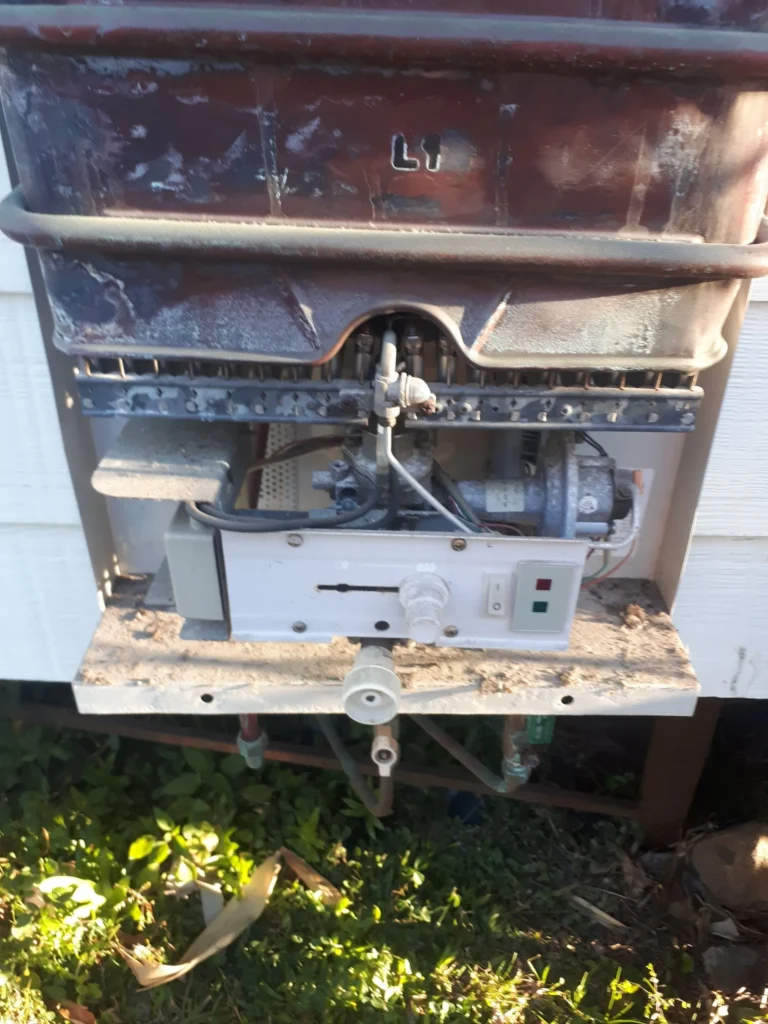 Gas hot water unit with its cover removed during a repair