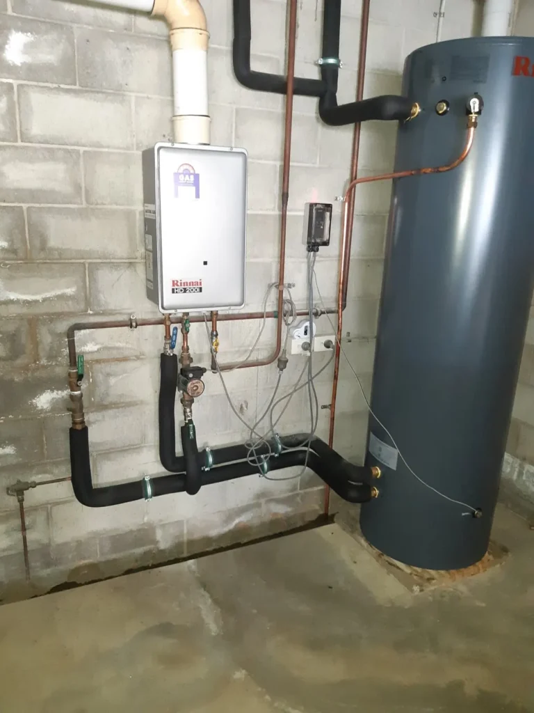 Wall-mounted gas hot water unit with its pipework and storage tank during a service call